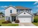 Charming two-story home featuring gray siding, a two-car garage, and well-maintained landscaping with a red star above the garage at 217 Windy Knoll Dr, Graham, NC 27253