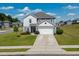 Attractive two-story home with gray siding, a well-manicured lawn, and a driveway, perfect for suburban living at 217 Windy Knoll Dr, Graham, NC 27253