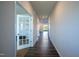 Long hallway with hardwood floors leading to a bright, open space with french doors on the left at 217 Windy Knoll Dr, Graham, NC 27253