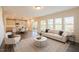 Open-concept living area featuring a kitchen, dining area, and living room with natural light and modern furnishings at 217 Windy Knoll Dr, Graham, NC 27253