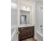 Bathroom with dark wood vanity, white countertop, and shower-tub combo at 239 Faith Avenue, Sanford, NC 27330
