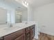 Bright bathroom features a dual sink vanity, tile flooring, and a shower at 239 Faith Avenue, Sanford, NC 27330