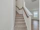 Carpeted stairs with white risers and wood handrail at 239 Faith Avenue, Sanford, NC 27330