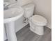 A well-lit bathroom featuring modern fixtures, including a pedestal sink and a standard toilet at 2432 Nassau Trce, Fuquay Varina, NC 27526
