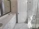 Bright bathroom featuring a glass shower with marble tile, double vanity, and modern fixtures at 2432 Nassau Trce, Fuquay Varina, NC 27526