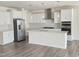Modern kitchen featuring white cabinets, stainless steel appliances, a tile backsplash, and a kitchen island at 2432 Nassau Trce, Fuquay Varina, NC 27526