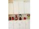 Kitchen featuring modern white cabinets and a beautiful backsplash, accented by sleek appliances and décor at 2432 Nassau Trce, Fuquay Varina, NC 27526