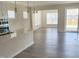 Open-concept living space featuring hardwood floors, plentiful windows, a modern island, and access to the patio at 2432 Nassau Trce, Fuquay Varina, NC 27526