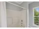 Bathroom featuring a white shower and tub with a window providing natural light at 2521 Friedland Pl # 303, Raleigh, NC 27617