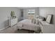 Bedroom with bed with decorative pillows, desk, shelves, and a sun-filled window at 2521 Friedland Pl # 303, Raleigh, NC 27617