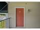 Condo front door with tan siding, overhead light, and black awning on the side with views of trees in the distance at 2521 Friedland Pl # 303, Raleigh, NC 27617