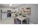 Eat-in kitchen features white cabinets, marble floors, stainless appliances, and modern hanging art at 2521 Friedland Pl # 303, Raleigh, NC 27617