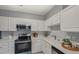 Bright kitchen features white cabinets, stainless steel appliances, and white countertops at 2521 Friedland Pl # 303, Raleigh, NC 27617