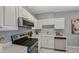 Kitchen with stainless steel appliances, white cabinets, white countertops, and marble-look tile flooring at 2521 Friedland Pl # 303, Raleigh, NC 27617