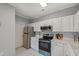 Charming kitchen features stainless steel appliances, white cabinets, white countertops, and tile flooring at 2521 Friedland Pl # 303, Raleigh, NC 27617