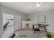 Living room features gray walls, carpeted floor, ceiling fan, art, and slider door to office at 2521 Friedland Pl # 303, Raleigh, NC 27617