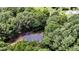Aerial view of a home with a dark roof nestled among mature trees at 26 Shadymont Dr, Pittsboro, NC 27312