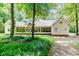 Rear view of home featuring a screened porch, nestled within a serene, wooded lot at 26 Shadymont Dr, Pittsboro, NC 27312