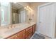 Bathroom featuring double sinks, granite counters, wood cabinets, and plenty of mirror space at 26 Shadymont Dr, Pittsboro, NC 27312
