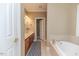 Bathroom featuring double sinks, a soaking tub, and a separate doorway at 26 Shadymont Dr, Pittsboro, NC 27312