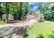 Paver driveway leading to a detached garage, set amidst a lush, wooded landscape at 26 Shadymont Dr, Pittsboro, NC 27312