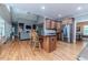 Open kitchen with breakfast bar, stainless steel appliances, and hardwood floors flowing into the living area at 26 Shadymont Dr, Pittsboro, NC 27312