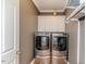 Well-lit laundry room featuring a modern washer and dryer and ample cabinet space for storage at 26 Shadymont Dr, Pittsboro, NC 27312