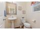 Cozy powder room featuring modern fixtures, a pedestal sink, and wooden floors at 2810 Catamaunt, Durham, NC 27704