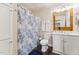 Bright bathroom featuring a blue and white patterned shower curtain, vanity, and decorative mirror at 309 E End Ave, Durham, NC 27703