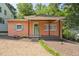 Charming home featuring a cozy front porch, accented by a colorful facade, window shutters, and a well-manicured gravel yard at 309 E End Ave, Durham, NC 27703