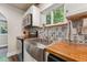 Kitchen with stainless steel appliances, tiled backsplash, and wooden countertops at 309 E End Ave, Durham, NC 27703