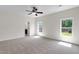 Large bedroom with neutral carpet, ceiling fan, two windows providing ample light, and an ensuite bathroom at 315 Sugarpine Trl, Clayton, NC 27520