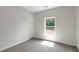 Bright bedroom with neutral carpet, white trim, and a window bringing in natural light at 315 Sugarpine Trl, Clayton, NC 27520