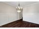 Elegant dining room with dark hardwood floors, chandelier lighting, wainscoting detail, and neutral paint at 315 Sugarpine Trl, Clayton, NC 27520