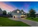 Beautifully landscaped two-story home with a two-car garage, lit up at dusk with a colorful evening sky at 315 Sugarpine Trl, Clayton, NC 27520