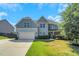 Charming two-story home with a two-car garage, manicured lawn and beautiful curb appeal under a blue sky at 315 Sugarpine Trl, Clayton, NC 27520
