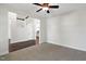 Spacious living room with plush carpet, ceiling fan, and open access to the kitchen and staircase at 315 Sugarpine Trl, Clayton, NC 27520