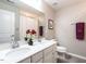 Elegant bathroom has double sinks, white cabinetry, and tasteful decor at 3441 Jordan Shires Dr, New Hill, NC 27562