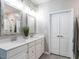 Bright, renovated bathroom featuring double sinks, custom framed mirrors, and linen closet at 3441 Jordan Shires Dr, New Hill, NC 27562