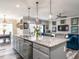 Open concept kitchen features a granite-topped island with pendant lighting and modern stainless steel appliances at 3441 Jordan Shires Dr, New Hill, NC 27562