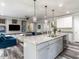 Stylish kitchen island with stainless steel appliances, undermount sink, and view of a living area at 3441 Jordan Shires Dr, New Hill, NC 27562