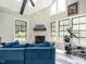 Bright sunroom featuring a stone fireplace, vaulted ceilings, ceiling fan, and exercise machine at 3441 Jordan Shires Dr, New Hill, NC 27562