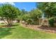 Landscaped backyard featuring a shed, garden beds and a charming swing bench, ideal for relaxation at 409 Trail Two, Burlington, NC 27215