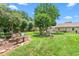 Beautiful landscaped backyard featuring lush lawn, mature trees, and a charming outdoor space at 409 Trail Two, Burlington, NC 27215