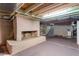Unfinished basement with exposed beams, concrete flooring, and a brick fireplace, ready for customization at 409 Trail Two, Burlington, NC 27215