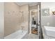 Bathroom with a white tiled bathtub and shower, complete with chrome fixtures and a modern wall finish at 409 Trail Two, Burlington, NC 27215
