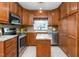 Well-lit kitchen boasts stainless appliances, granite countertops, and wood cabinets, offering ample storage space at 409 Trail Two, Burlington, NC 27215