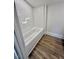 Bathroom shower and bathtub feature all white materials with wood-look floor at 41 Lakewood Dr, Roxboro, NC 27573
