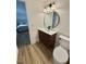 Bathroom featuring a round mirror over a wood vanity, and wood-look flooring at 41 Lakewood Dr, Roxboro, NC 27573