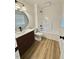 Modern bathroom with wood-look flooring, a round mirror, and a shower-tub combination at 41 Lakewood Dr, Roxboro, NC 27573